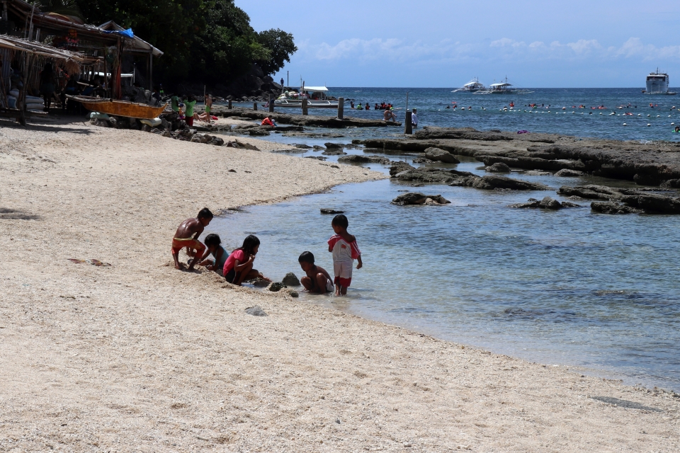 Enfants jouant sur la plage d'Apo